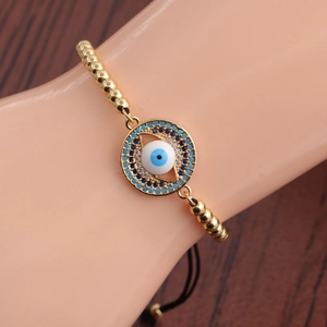 Detailed shot of an adjustable evil eye bracelet with blue zircon and gold beads