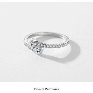 Detail of s925 silver ring featuring intertwined heart gems and crystal pavé band