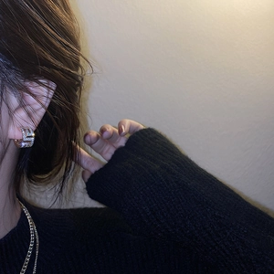 Gros plan d'une boucle d'oreille dorée géométrique en C avec cristaux sur un mannequin