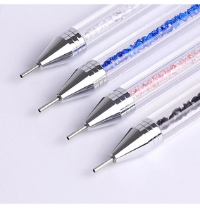 Detailed macro view of four acrylic nail art dotting pens with colored crystal fillings
