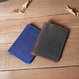 Close-up of vintage leather wallet showing matte texture and orange contrast stitching