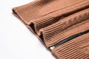 Macro view of caramel knit cardigan featuring detailed zip and ribbed texture finish