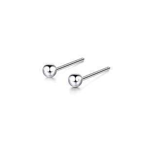 Macro shot of silver ball stud earrings featuring a high-polished mirror finish surface