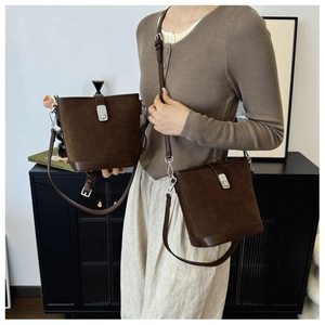 Detailed view of the dark brown matte suede bucket bag with silver twist lock closure