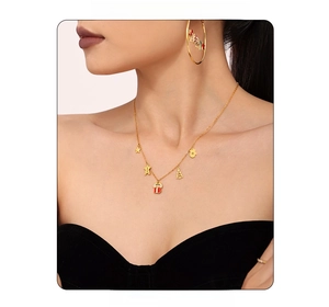 Close-up of gold-plated Christmas jewelry set featuring enamel pendants and hoop earrings