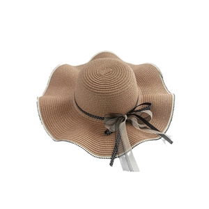 Brown straw sun hat with wide wavy brim and mesh polka dot bow decoration for summer beach