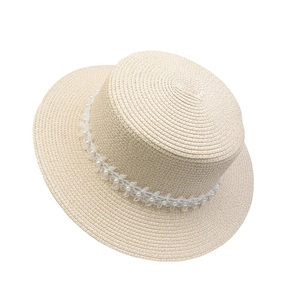 Detailed close-up of a wide brim straw sun hat featuring white pearl and mesh lace trim