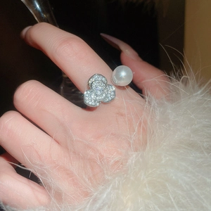 Détail macro de la bague fleur de camélia avec cristaux et une perle blanche