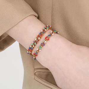 Detail of 18K gold-plated Cuban link bracelets with multi-color enamel on a model wrist