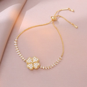 Detailed view of rotating golden clover charm with sparkling zircons and adjustable slider