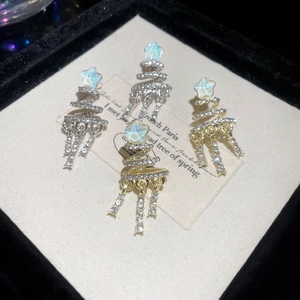 Macro detail of spiral Christmas tree earrings with star opal and sparkling diamond tassels