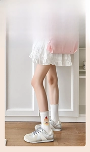 Détail de chaussette en coton blanc avec bord à volants et motif de gâteau cerise