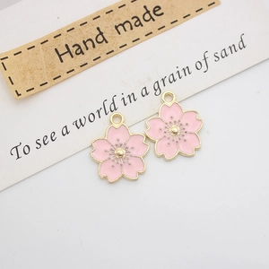 Detail of pink cherry blossom enamel charms with golden alloy edges for DIY jewelry making