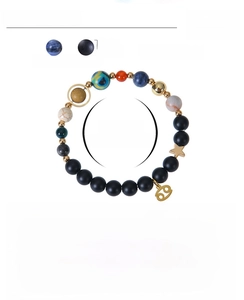 Detail view of 8mm beaded planet bracelet with matte black stones and gold zodiac charms