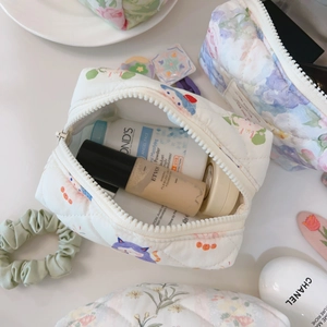 Detailed close-up of quilted cotton cosmetic bags with floral patterns and zipper closure