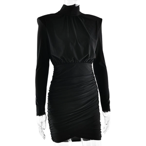 Détail de la robe noire moulante avec épaulettes et textures plissées à la taille
