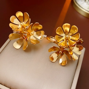 Detailed close-up of golden flower stud earring with metallic luster and polished finish