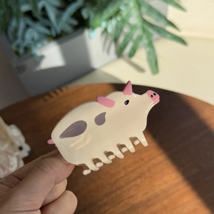 Détail de la pince à cheveux en acétate motif vache avec structure de maintien