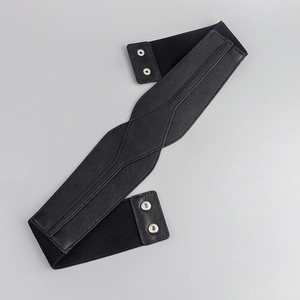 Detail of black elastic waist belt featuring silver metal snap buttons and faux leather finish