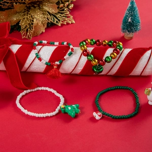 Close-up of Christmas charm bracelets with Santa and reindeer pendants on festive display