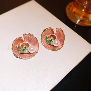 Detailed shot of gold-plated lotus earrings with pink and green enamel and pearls