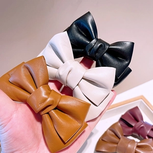 Gros plan de barrettes à nœuds en cuir PU de qualité, couleurs noir, beige et marron