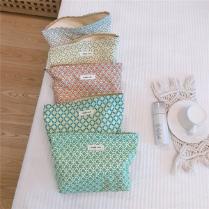 Detailed macro of five floral cotton cosmetic bags with zip and 'simple wish' label