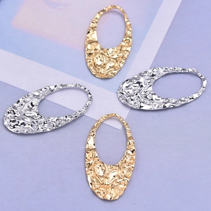 Detailed macro view of 304 stainless steel oval textured pendants in gold and silver finish