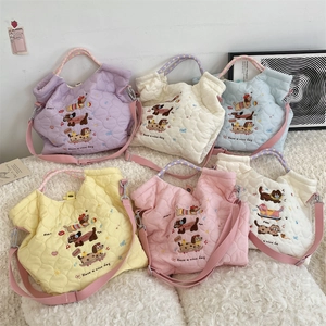 Detail of quilted heart patterns and cute animal embroidery on colorful tote bags