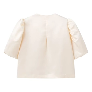 Detail view of the back of a cream satin puffed sleeve blouse with silk-like glossy finish