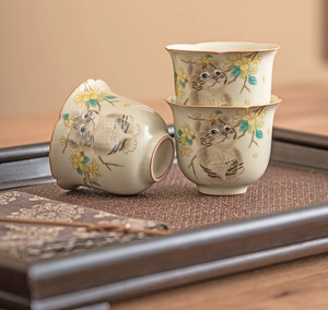 Macro detail of Ru kiln ceramic teacups featuring cat patterns and crackle glaze texture