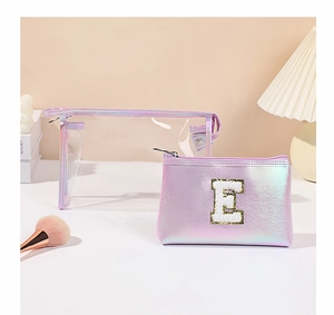 Dettaglio del set di borse trucco olografiche con patch glitterata della lettera E