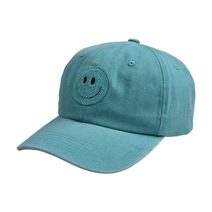 Detailed shot of green washed cotton baseball cap with sequined smiley face patch