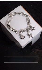 Detailed shot of retro silver plated bracelet featuring flower and horse lucky charms