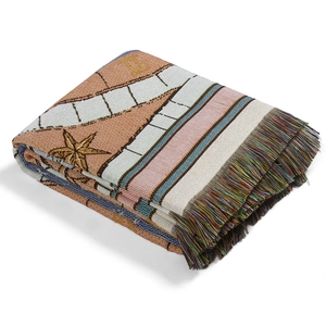 Detail of stacked bohemian outdoor blanket featuring colorful fringes and jacquard weave