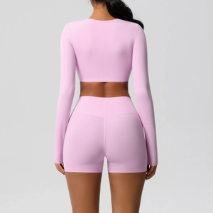 Back view of light pink yoga set with long sleeve crop top and high waist sports shorts