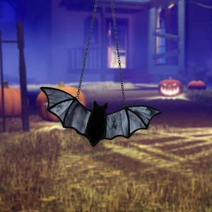 Detail of hanging Halloween bat pendant with textured wings and silver metal chain