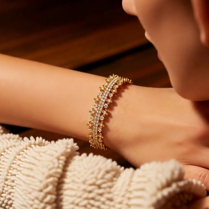 Detailed close-up of 18k gold plated hollow bangle with zircons on a model wrist