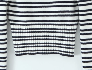 Nahaufnahme der gestrickten Streifentextur und des gerippten Saums an Ärmeln und Saum