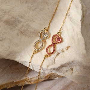 Infinity symbol necklace in gold with sparkling white and pink zircon crystals
