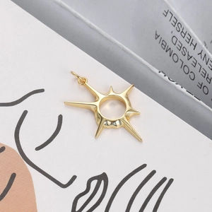 Macro shot of 18K gold plated starburst pendant with polished finish and bail