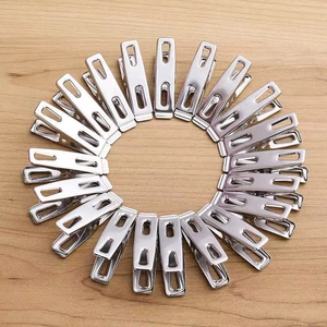 Macro shot of stainless steel clothes pegs arranged in a circular pattern on wood