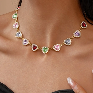 Gros plan d'un collier en or de luxe avec pendentifs cœurs en cristal colorés sur mannequin