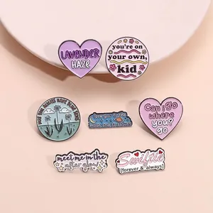 Set of pastel Taylor Swift inspired enamel pins with lyrics on a soft beige background