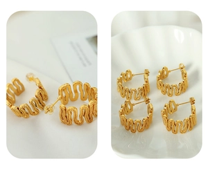 Detail of gold-plated C-shaped wavy earrings featuring elegant frosted textured finish