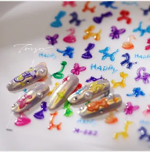 Detailed macro of 3D balloon animal nail stickers with colorful dog and swan designs