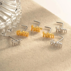 Minimalist L-shaped nose studs with engraved letters them her and him in gold and silver