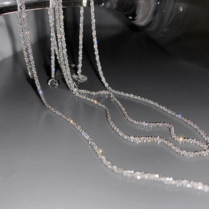 Close-up of a sparkling silver gypsophila chain necklace with light reflections.