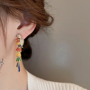 Detail of parrot drop earrings with colorful enamel feathers and sparkling zircon stones