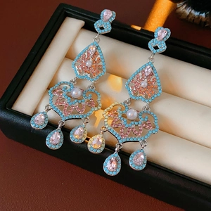 Détail de boucles d'oreilles vintage en argent avec turquoise, pierres roses et perles